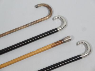 Four various silver and other walking cane sticks