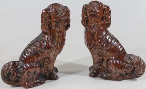 A pair of late 19thC glazed brown stoneware spaniels