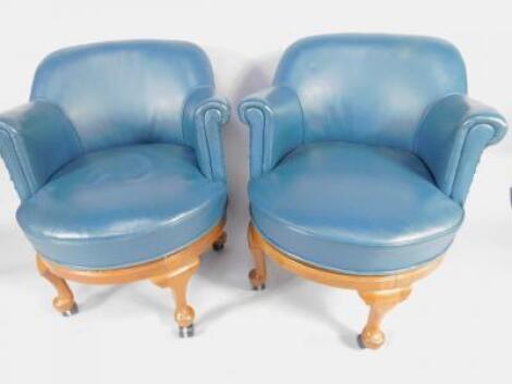 A pair of mahogany and blue leather revolving tub armchairs