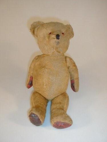 A mid 20thC teddy bear with short golden mohair plush and wood wool stuffing