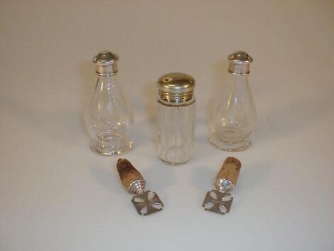 A pair of Ecclesiastical glass cruets with silver screw tops