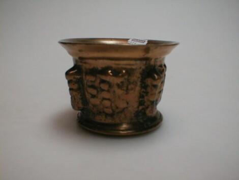 A 17thC bell metal mortar cast with fruit and stylized decoration
