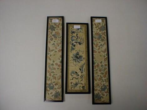 A pair of early 20thC Chinese fabric panels embroidered in coloured threads with flowers