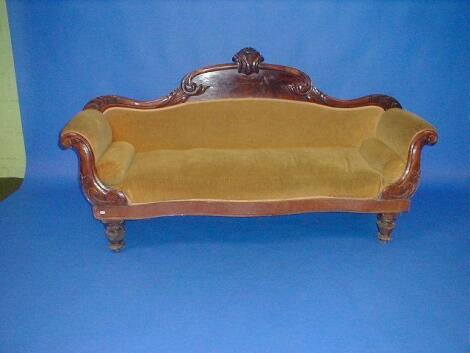 A Victorian mahogany sofa with flamed panelled scrolling back