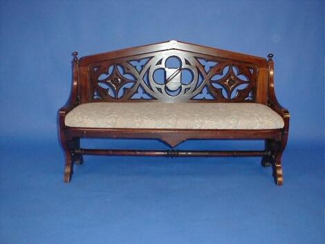 A Victorian mahogany bench seat with pierced and carved gothic back and uprights