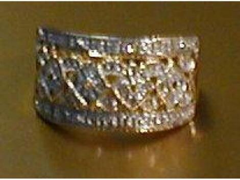 A dress ring, a wide pierced band with lozenge motifs set with tiny diamonds