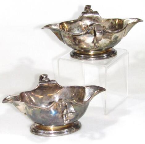 A Harlequin pair of George II silver sauce boats