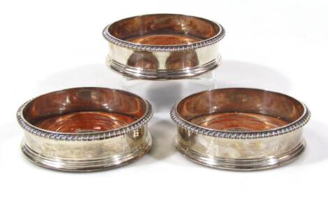 A harlequin set of three George III silver coasters