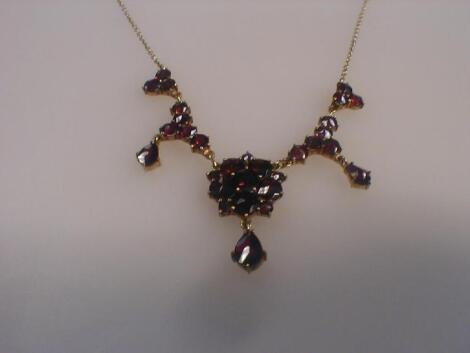 A garnet set necklace of clusters and drops set in yellow metal stamped 333