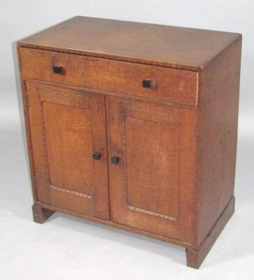 An early 20thC oak Arts and Crafts Cotswold Gimson style side cabinet