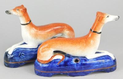 A pair of early 20thC Staffordshire recumbent greyhound inkwells