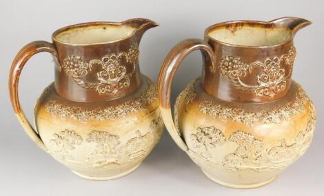 A pair of 19thC stoneware relief moulded jugs