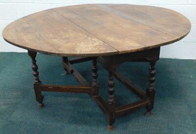 An 18thC oak drop leaf gate leg dining table