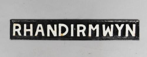 A black and white cast iron rectangular sign 'Rhandirmwyn'