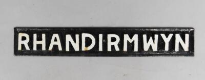 A black and white cast iron rectangular sign 'Rhandirmwyn'