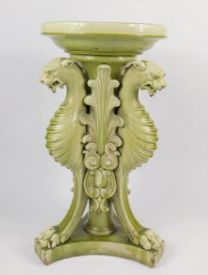 A Victorian late 19thC pottery green glazed jardiniere stand