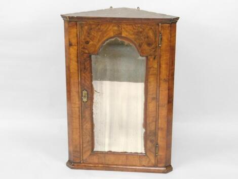 An 18thC figured walnut hanging corner cupboard