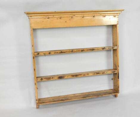 An antique graduated pine hanging plate rack