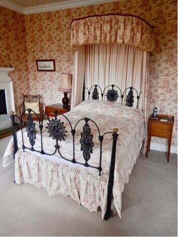 A Victorian half tester cast iron framed bed