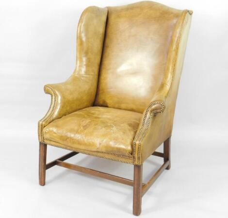 A George III mahogany framed leather upholstered wingback chair