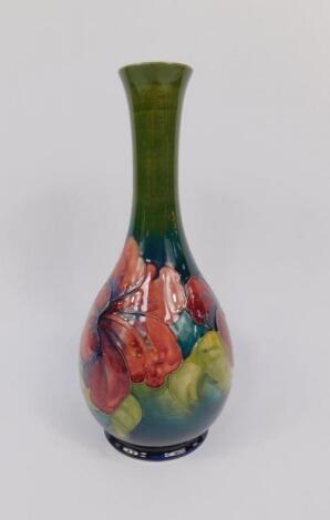 A Moorcroft pottery slender necked vase decorated in the Hibiscus pattern