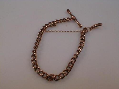 A 9ct rose gold curb link bracelet with attached T bar