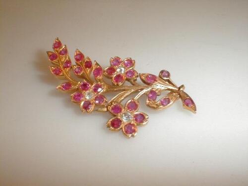 A yellow metal brooch of flower spray design set with Burmese rubies and