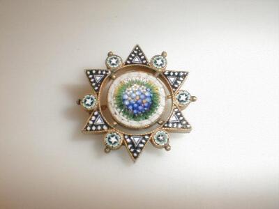 A six point star brooch with enamel points and a micro-mosaic floral rondel centre