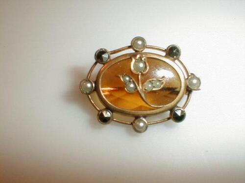 An Edwardian brooch with central yellow stone set atop with a seed pearl set tulip