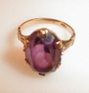 A purple paste set in yellow metal ring stamped 9ct