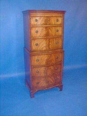 A reproduction flamed mahogany serpentine chest-on-chest. 51" high