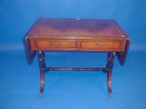 A reproduction flamed mahogany sofa table