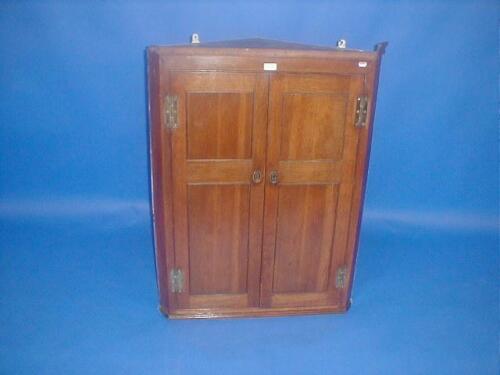 A George III oak two door hanging corner cupboard