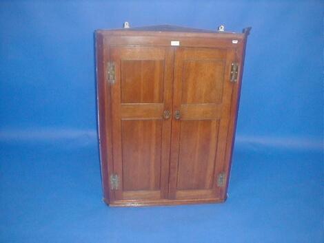 A George III oak two door hanging corner cupboard