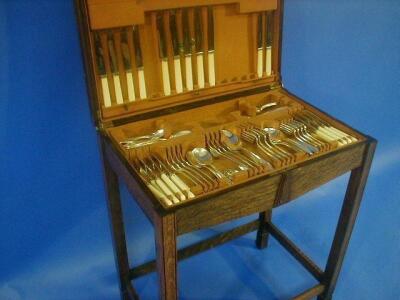 An Art Deco oak canteen on stand containing community plate cutlery comprising