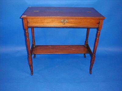 An Edwardian walnut writing desk with part lift top and drop drawer revealing