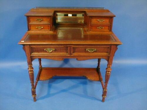 A late Victorian walnut escritoire with galleried mirrored and drawer back