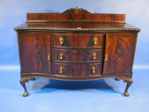 A 1920's flamed mahogany Serpentine sideboard with gadrooned top and an