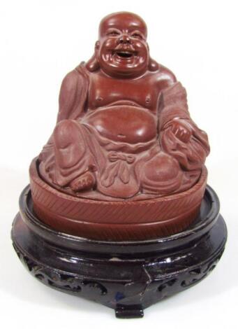 A large red stoneware style Buddha
