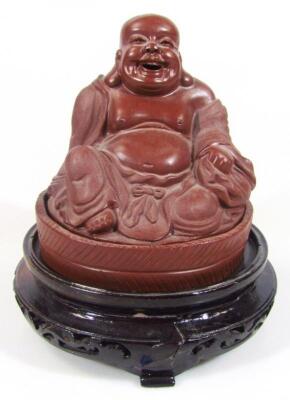 A large red stoneware style Buddha