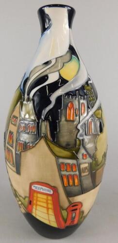 A Moorcroft pottery vase decorated with a village