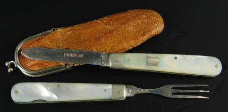 A silver and mother of pearl handled combination knife and fork set