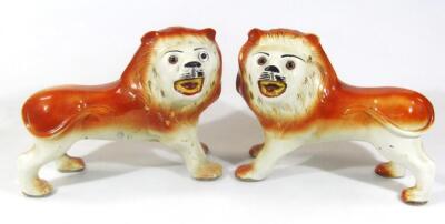 A pair of very early 20thC pottery figures of lions