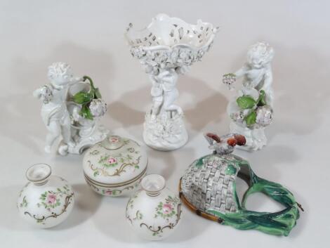 A pair of Continental porcelain cherubic centrepiece figures