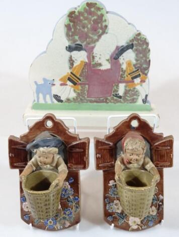 A pair of early 20thC Austrian partially glazed and terracotta wall pockets