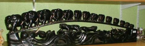 A Sri Lankan carved ebony train of fourteen graduated elephants over a