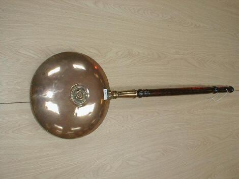 A Victorian copper warming pan with turned handle