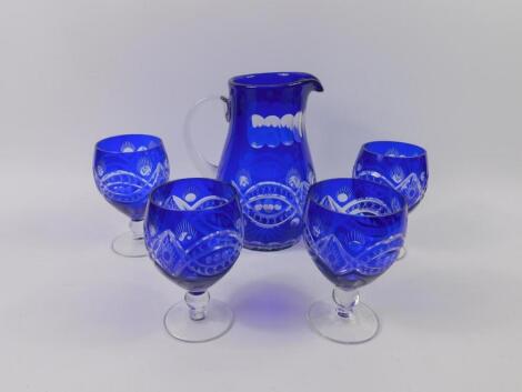 A Continental blue flashed glass water jug and four glasses.