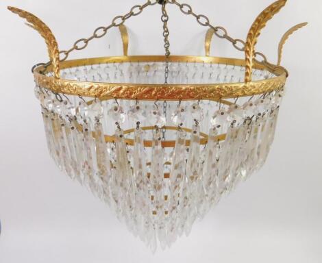 A brass five tier chandelier with cut glass tear drops