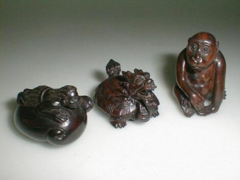 Three hardwood netsuke of a monkey